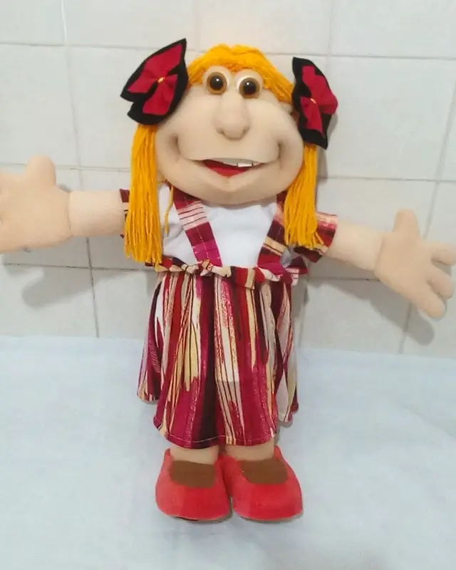 Boneca loira com laços vermelhos e vestido listrado vermelho