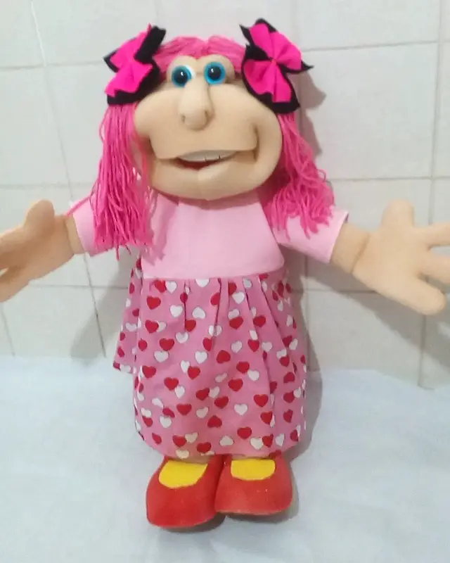 Boneca de cabelo rosa com laços pretos e vestido de corações