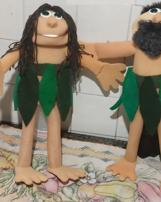 Eva, fantoche de cabelo longo escuro e saia de folhas verdes